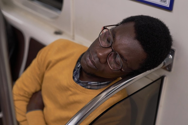Zmęczony człowiek śpi w wagonie metra