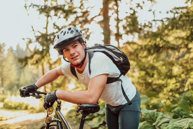 Zmęczony rowerzysta w sportowym stroju i kasku robiący sobie przerwę po treningu w plenerze Zdrowy mężczyzna rasy kaukaskiej spędzający wolny czas na treningu na świeżym powietrzu Wysokiej jakości zdjęcie