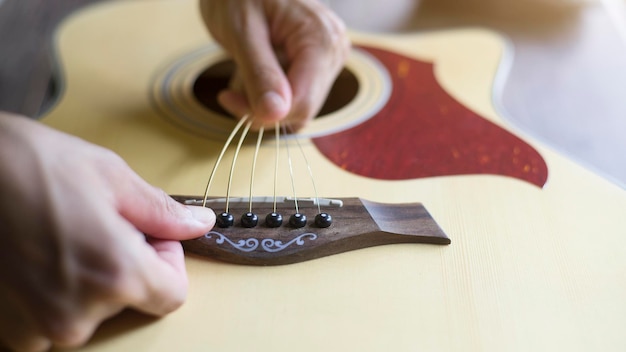 Zmień struny gitary akustycznej Kroki, aby włożyć wszystkie 6 strun gitarowych Zbliżenie
