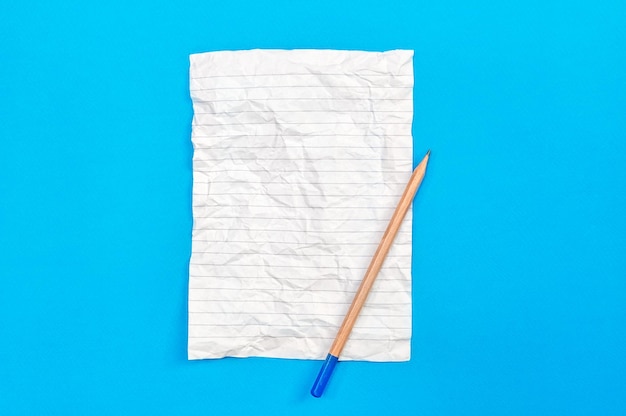 Zmięty arkusz notatnika z ołówkiem na niebiesko