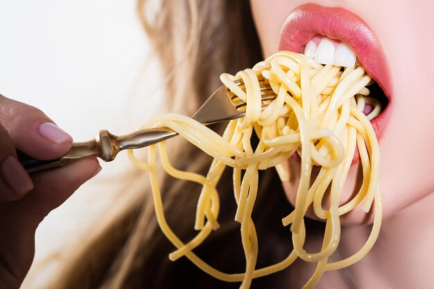 Zmysłowe usta, otwarte usta z bliska. Dziewczyna zjada makaron spaghetti.