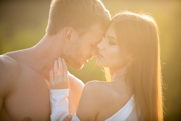 Zmysłowy pocałunek Mężczyzna pocałował delikatną kobietę o zachodzie słońca Zmysłowy portret zakochanej młodej pary Kochająca para obejmująca się i całująca