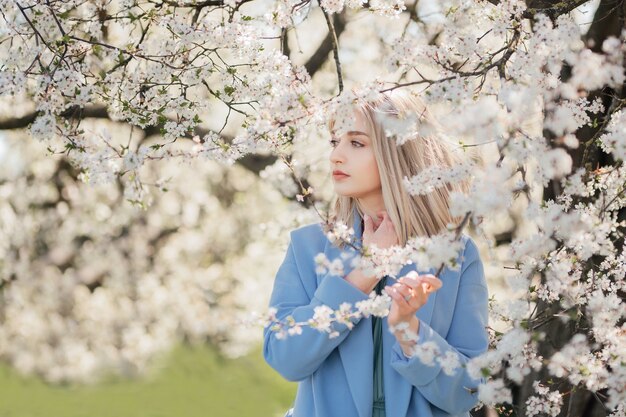 Zmysłowy portret młodej blondynki wśród kwitnącej jabłoni