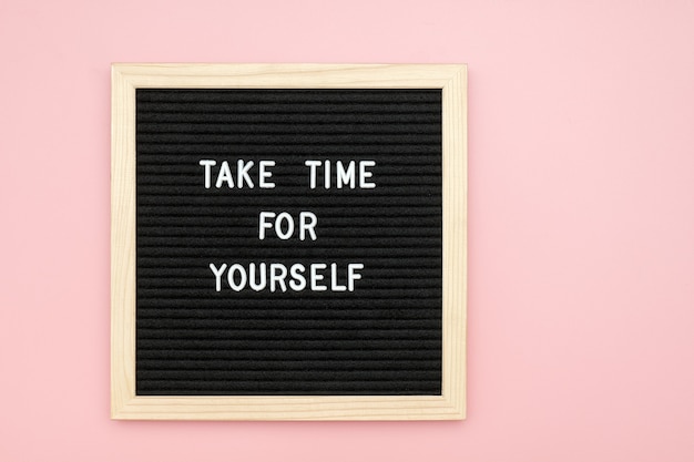 Znajdź czas dla siebie. Motywacyjny cytat na tablicy na różowym tle. Widok z góry Mieszkanie leżące Kopiuj przestrzeń