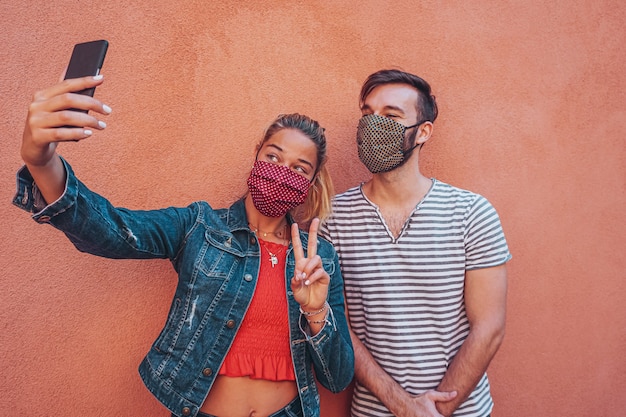 Znajomi robią sobie selfie z maską na twarz w czasie koronawirusa dla ochrony