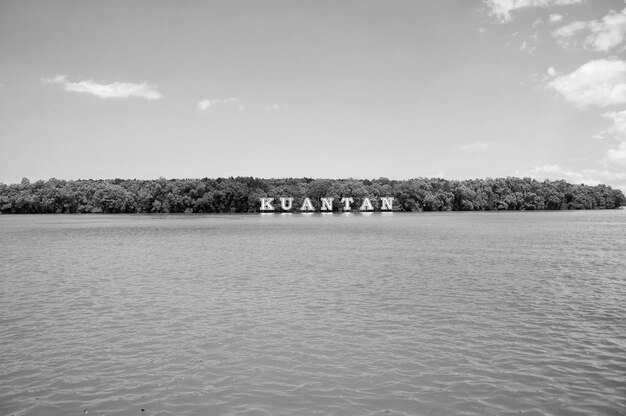 Znak Kuantan na rzece w Malezji Woda rzeczna i zielone wybrzeże na błękitnym niebie Letnie wakacje Odkrycie i przygoda Wanderlust i koncepcja podróży