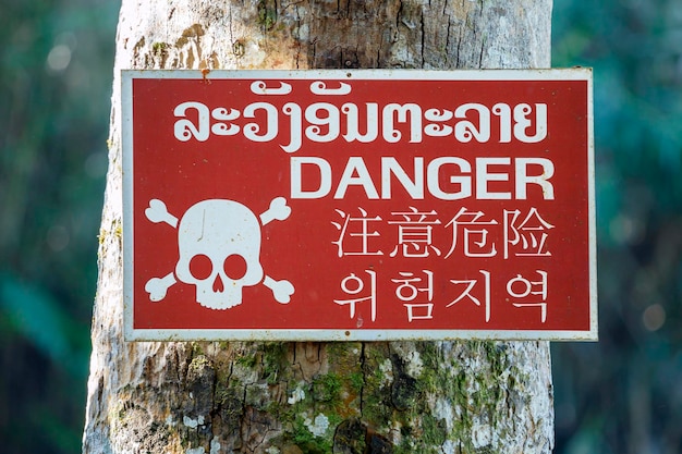 Znak NIEBEZPIECZEŃSTWA napisany w języku tajskim, angielskim, chińskim i koreańskim.