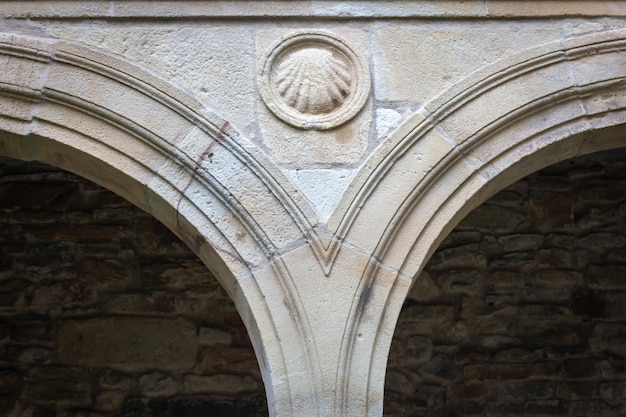 Znak powłoki na średniowiecznej ścianie w klasztorze. Koncepcja pielgrzymki. Symbol Camino de Santiago.