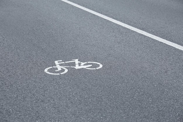 Znak rowerowy na szarej nawierzchni asfaltowej