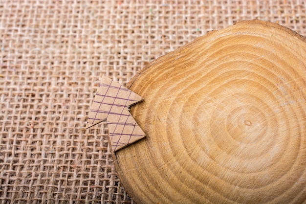 Znak strzałki wycięty z brązowego papieru na kawałku drewna