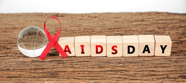 Zdjęcie znak świadomości aids czerwona wstążka z udawaną kulą ziemską koncepcja światowego dnia aids