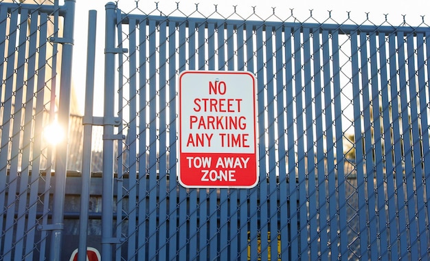 Znak zakazu parkowania zardzewiały i postarzony na rozmytym tle miejskim, przekazującym miejski charakter