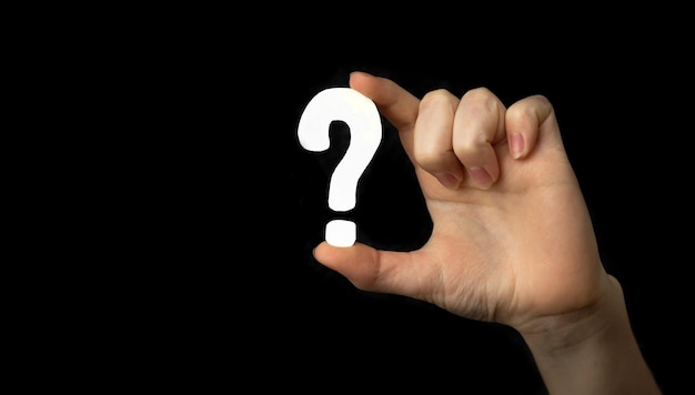 Znak zapytania w ręku. Ikona pytania, symbol na czarnym tle. Zdjęcie koncepcyjne wątpliwości, edukacji lub FAQ