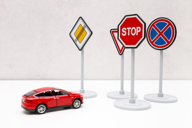 znaki drogowe blokują drogę czerwonego samochodu zabawkowego