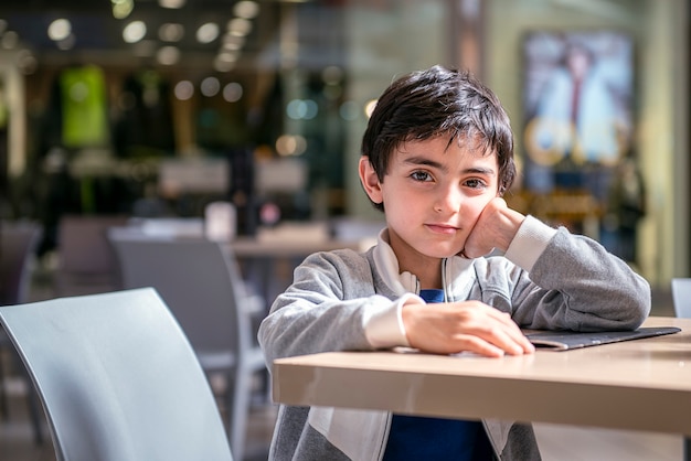 Znudzone Dziecko Czeka Przy Stoliku Restauracyjnym W Centrum Handlowym