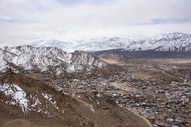 Zobacz krajobraz i panoramę miasta Leh Ladakh Village z wysokim pasmem górskim z punktu widokowego Świątyni Tsemo Maitreya lub klasztoru Namgyal Tsemo podczas sezonu zimowego w Dżammu i Kaszmirze w Indiach