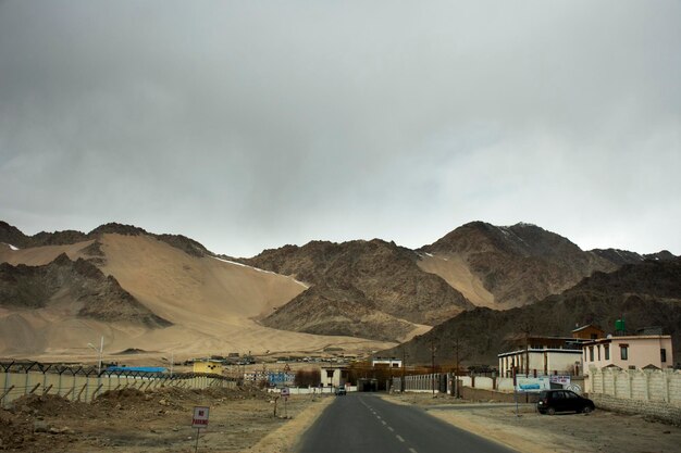 Zobacz krajobraz przy drodze z Indianami jeżdżącymi samochodem po autostradzie Srinagar Leh Ladakh przejdź do punktu widokowego zbiegu Indusu i rzeki Zanskar w Leh Ladakh w Dżammu i Kaszmirze w Indiach zimą