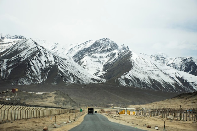 Zobacz krajobraz przy drodze z Indianami jeżdżącymi samochodem po autostradzie Srinagar Leh Ladakh przejdź do punktu widokowego zbiegu Indusu i rzeki Zanskar w Leh Ladakh w Dżammu i Kaszmirze w Indiach zimą