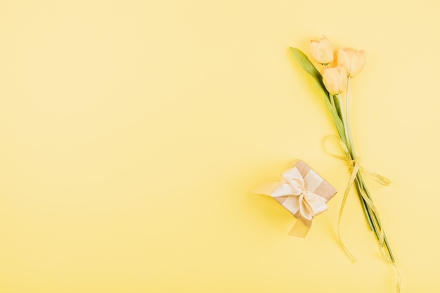 Żółci Tulipany Kwitną I Prezenta Pudełko Na Pastelowym Tle. świąteczne Urodziny Leżały Płasko