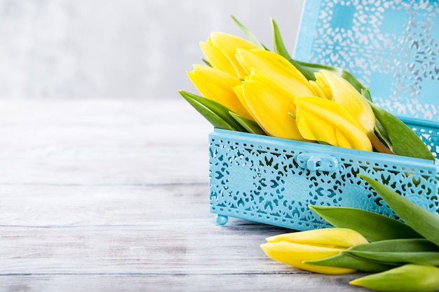 Żółci tulipany w błękitnym metalu pudełku