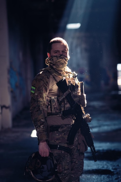 Żołnierz armii w mundurach bojowych z karabinem szturmowym i hełmem bojowym w nocnej misji na ciemnym tle. Niebieski i fioletowy efekt świetlny żelu. Zdjęcie wysokiej jakości