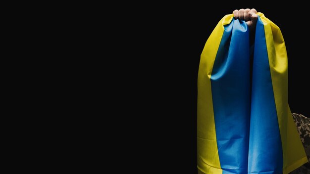 Żołnierz ukraiński dzierży sztandar niepodległego państwa Ukrainy Niezłomność i odwaga ludu w walce z najeźdźcą Niezłomny duch narodu Symbol niepodległości