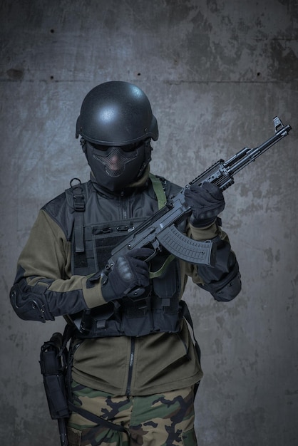 Żołnierz w hełmie z karabinem automatycznym w rękach