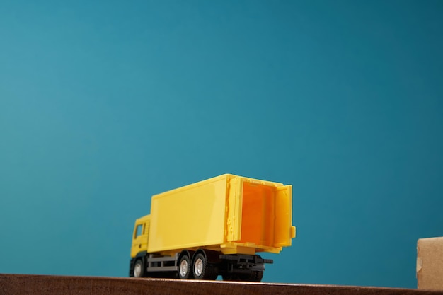 Żółta ciężarówka kontenerowa na niebieskim tle