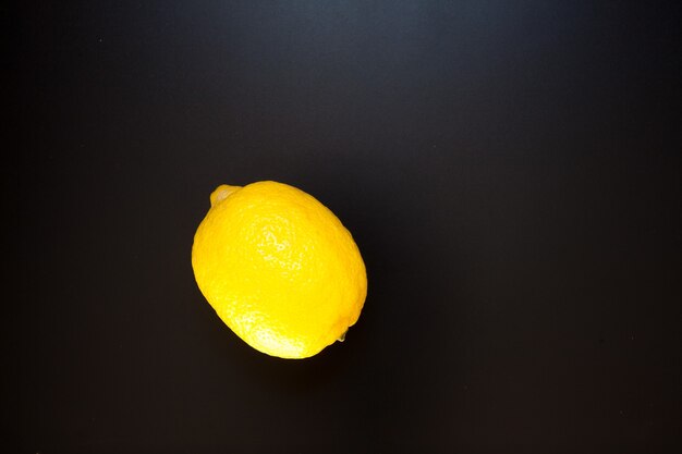 Żółta cytryna na czarnym stole