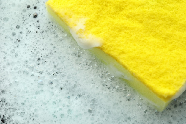 Żółta gąbka z pianką detergentową, z bliska
