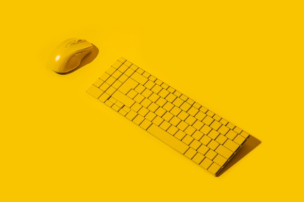 Żółta klawiatura bezprzewodowa i żółta mysz komputerowa na żółtym tle