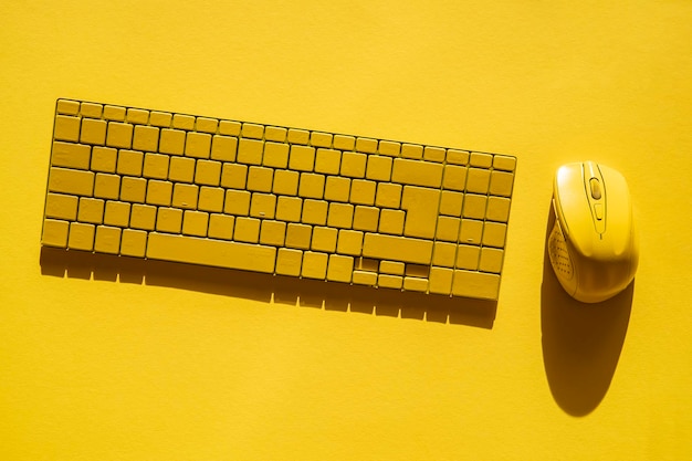 Żółta klawiatura i żółta mysz komputerowa na żółtym tle Płaski widok z góry