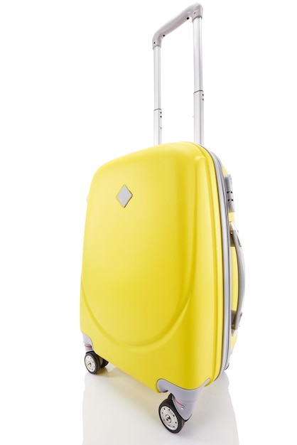 Żółta plastikowa kołowa kolorowa walizka z rękojeścią odizolowywającą na bielu