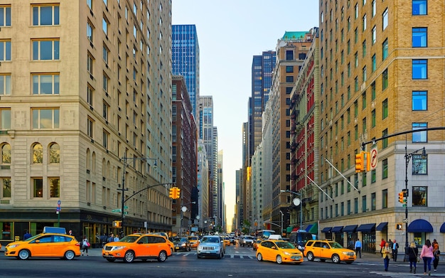 Żółta taksówka na drodze. Widok ulicy w dzielnicy finansowej na dolnym Manhattanie, Nowy Jork w USA. Skyline i pejzaż miejski z drapaczami chmur w Stanach Zjednoczonych Ameryki, NYC, USA. Amerykańska architektura.