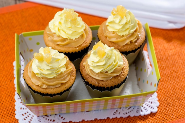 Żółte ciastko słodkie mleko dulce de leche w smaku pudełko na pomarańczowym tle.