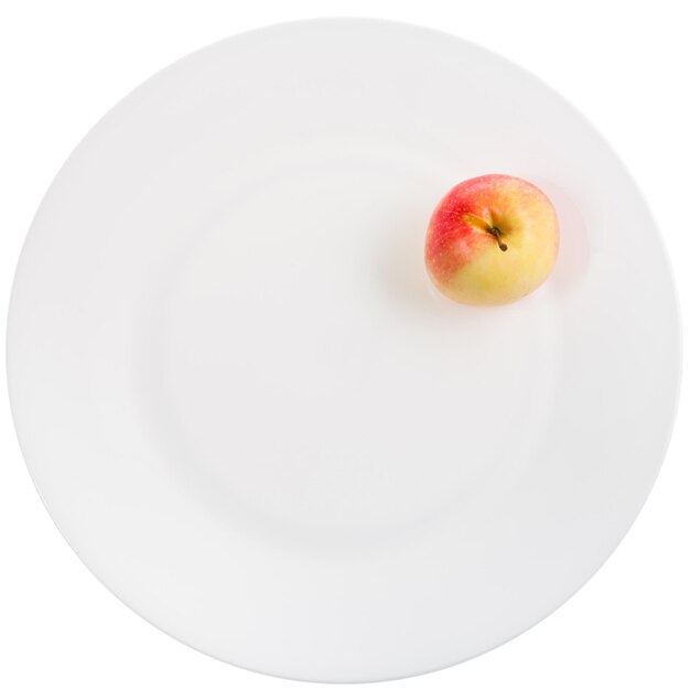 Zdjęcie Żółte czerwone jabłko na białym talerzu