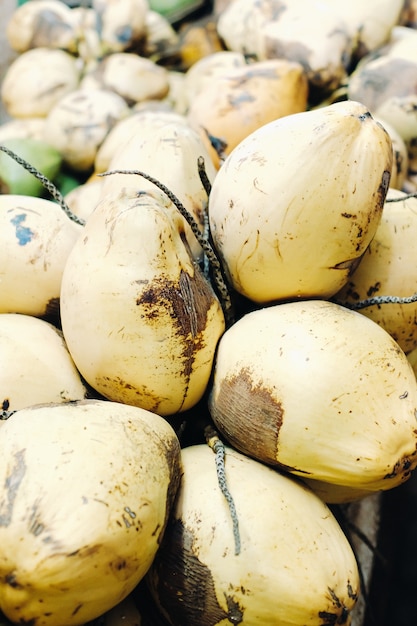 Zdjęcie Żółte kokosy są sprzedawane na rynku wyspy mauritius. sprzedaż owoców wegetariańskich na świeżym powietrzu. wiele orzechów kokosowych na rynku.