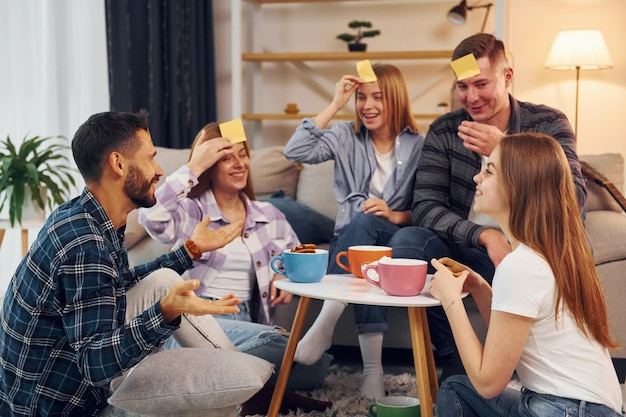 Żółte naklejki na czole Grupa przyjaciół ma razem imprezę w domu