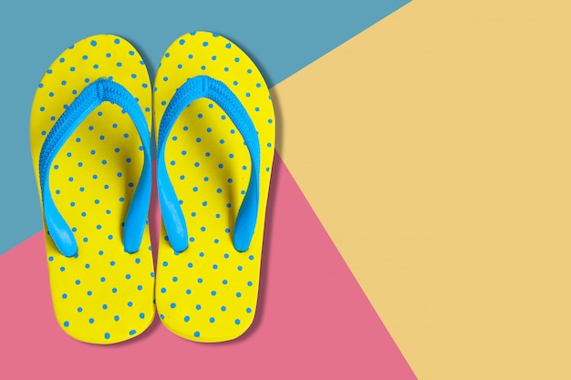 Żółte sandały na różowym i niebieskim tle koloru, płaskie świeckie zdjęcie