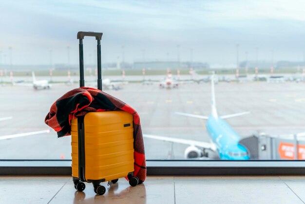 Żółte walizki na lotnisku przeciwko samolotowi Koncepcja podróży