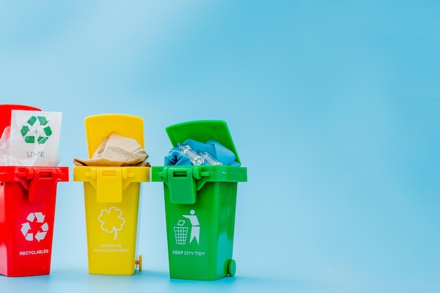 Żółte zielone i czerwone kosze z symbolem recyklingu na niebieskim tle Utrzymuj porządek w mieście Pozostawia symbol recyklingu Koncepcja ochrony przyrody