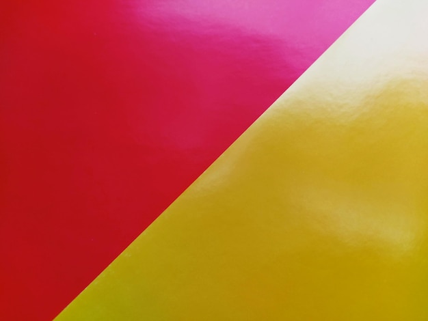 Żółtoróżowe jasne tło Ukośnie ułożone arkusze kolorowego papieru z gradientem i jasnym rozbłyskiem