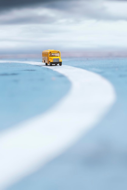 Zdjęcie Żółty autobus szkolny model zabawki na drodze płytka głębia ostrości skład educationback to school concept background