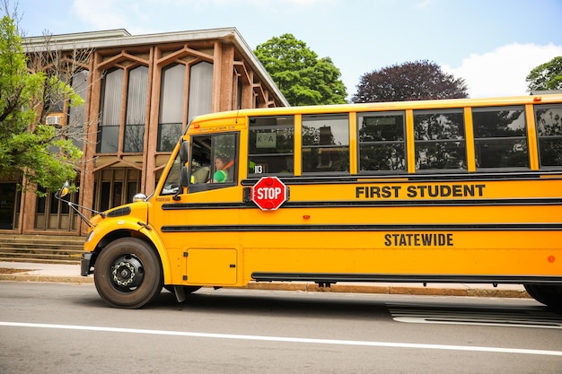 żółty autobus szkolny zaparkowany na tle śmiechu dzieci symbolizujących społeczność edukacyjną