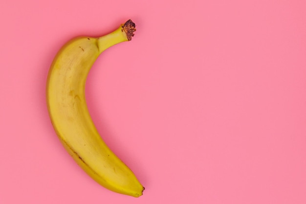 Żółty banan na różowym tle Widok z góry miejsce na kopię płaski leżał minimalistyczny projekt