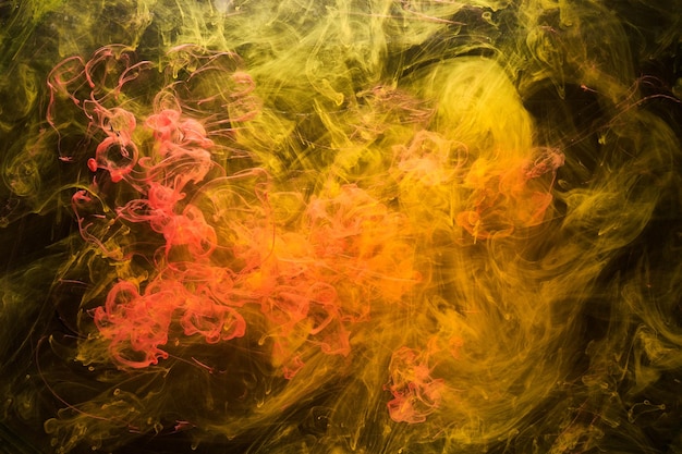Żółty dym na czarnym tle kolorowa mgła streszczenie wirujący atrament ocean morze pigment farba akrylowa pod wodą