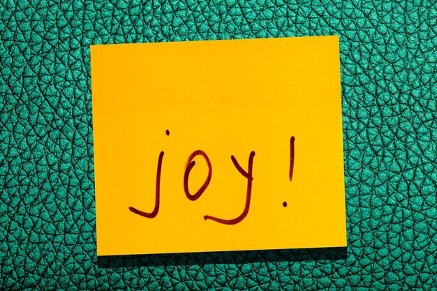Żółty lepki liść na ścianie. napis marker słowo radość
