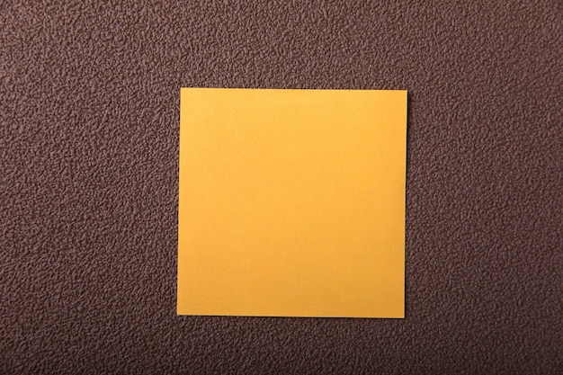 Żółty papier na brązowym tle