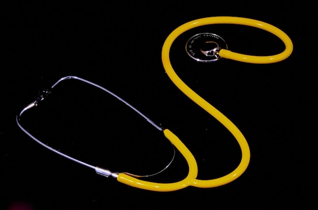 Żółty stetoskop narzędzi medycznych na czarnym tle