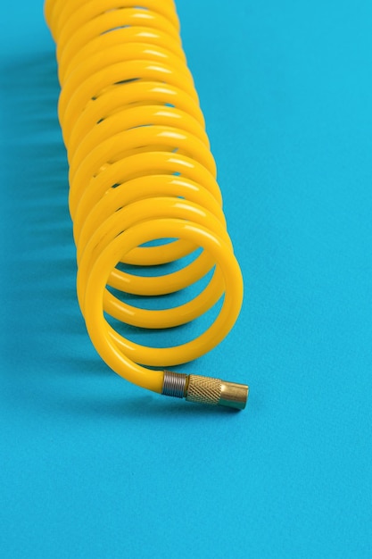 Żółty Wąż Kompresora Skręcony W Spiralę Na Niebieskim Tle